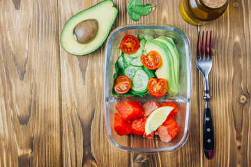 Healthy meal prep containers on wooden backgound.