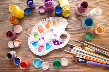 Multicolored plastic cans with paints. Artist workplace background. Old dirty Paints background. Colorful artist palette. Creativity, visual art concept. Art and craft.