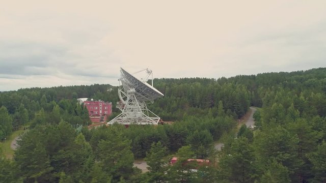 Aerial view of observatory and radio telescope in green summer forest.
