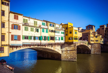 Fototapeta na wymiar Beautiful view of Arno River and stone medieval bridge Ponte Vecchio with of colorful houses. Famous landmark, Florence, Firenze, Tuscany, Italy.