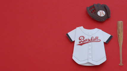 White baseball jersey, glove and bat laying flat on a red background with writing space