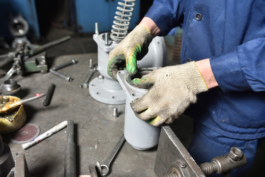 The base for the valve is mounted on an iron table for assembly at the factory and the worker installs and fastens the components.