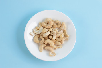 Cashews on a blue background. Superfood nuts healthy food