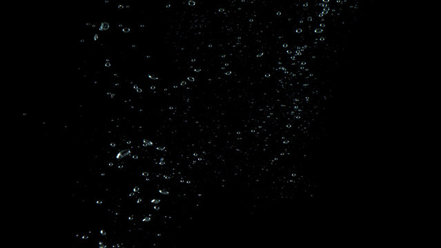Extream close-up images of water bubbles or soda or liquid texture that splashing and floating up to surface like a explosion in black color background for refreshing carbonate drink concept.