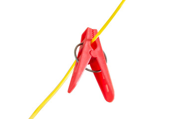 Red plastic washing line clothes pegs on a yellow cord isolated on white background