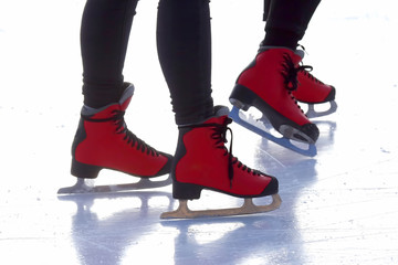 Naklejka premium Female legs in skates on an ice rink