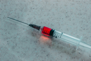 Syringe with red solution on white background