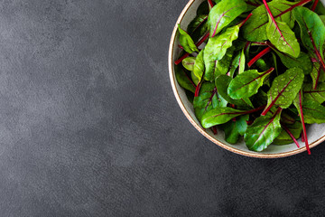 Fresh chard leaves on black background top view