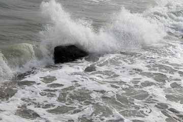 strong sea waves and foam with stones in the sea