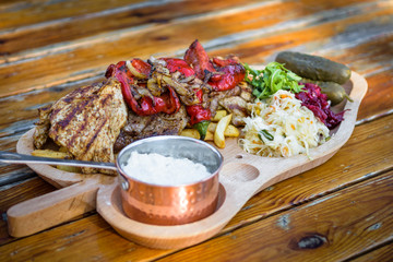  a set of meats with potatoes and salads