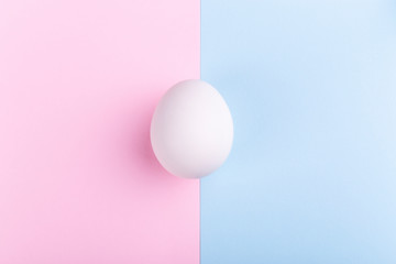 white egg on a pink blue background, concept Happy Easter
