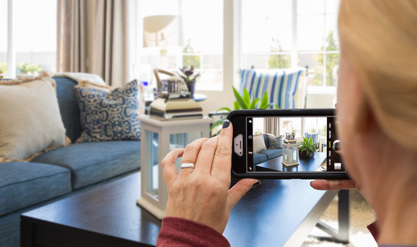 Woman Taking Pictures of A Living Room in Model Home with Her Smart Phone