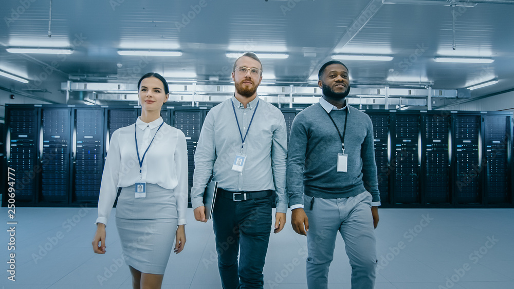 Aufkleber Professional Team of Data Center IT Specialists Walking Away From the Working Server Cabinets Rack Corridor with a Laptop Computer. They Are Dressed Smart.