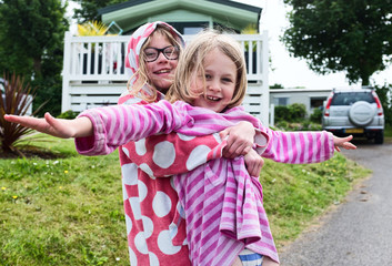 Two sisters playing outside there static holiday home cuddling and playing