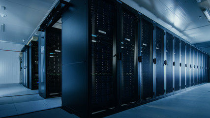 Shot of a Working Data Center With Rows of Rack Servers. Led Lights Blinking and Computers are...