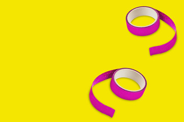 Two rolls of violet sticky tapes on yellow background with copy space for your text