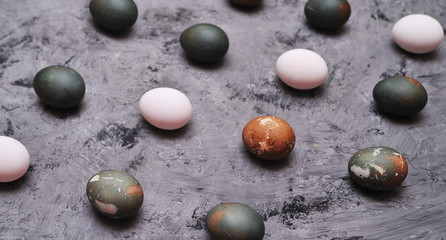 Chicken painted eggs in box on stone background.