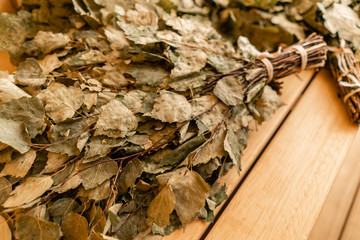 dry oak broom for a bath close-up. Wooden Finnish sauna interior. scoops and oaken besoms in steam bathroom
