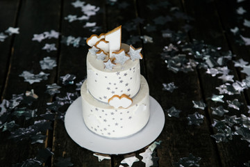 First birthday white cake with stars and one candle for little baby boy and decorations for cake smash. Black background