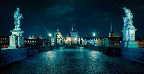 Prague. Famous Charles Bridge to the Old Town tower and St. Francis of Assisi Church (UNESCO). Czech republic, Europe. Blue night or evening.