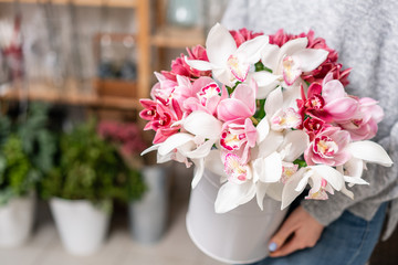 Japanese Wanda Orchid in metal vases in womens hands. Bunch pale pink. white. the concept of a florist in a flower shop. Wallpaper.