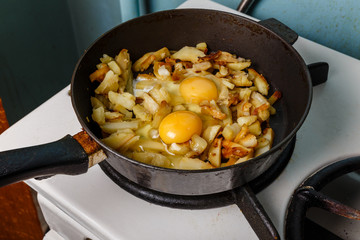 fried potatoes with egg in a frying pan, Food bachelor, Cooked by a male