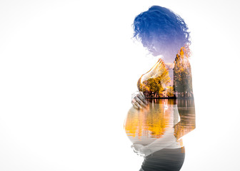 Double exposure. Silhouette of pregnant woman combined with a lake reflection, symbolizing the beginning of a new life.