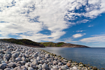 Fototapeta na wymiar The rocky beach on the coast of the Barents Sea in the north of Russia