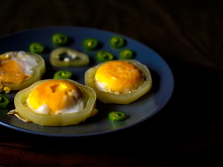 Little scrambled eggs on a blue plate. Fried eggs with bitter pepper.