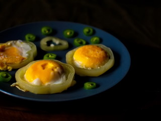 Little scrambled eggs on a blue plate. Fried eggs with bitter pepper.