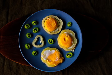 Little scrambled eggs on a blue plate. Fried eggs with bitter pepper.