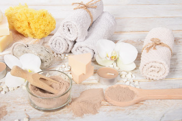 Fototapeta na wymiar home spa, candles, pumice, natural soap, dry powder for making a face mask,orchid for mother's day