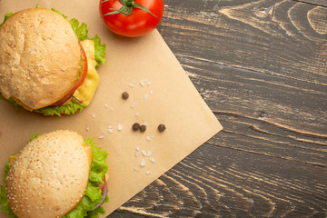 Delicious homemade burgers, burgers with beef, cheese, tomatoes, and salad. Top view with copy space.