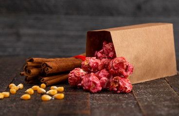 A Bag of Dark Red Cinnamon Popcorn on a Wooden Kitchen Table