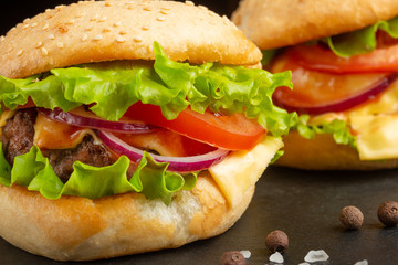 Delicious homemade burgers, burgers with beef, cheese, tomatoes, and salad. close up macro