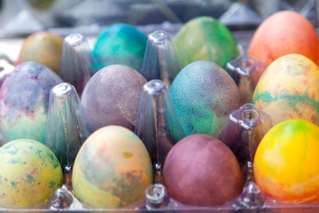 Group of Easter colored eggs in plastic container
