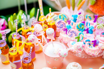 Candy bar with sweet cakes and decor items in bright pink colors. Cupcakes, muffins, ice creams, lollypops