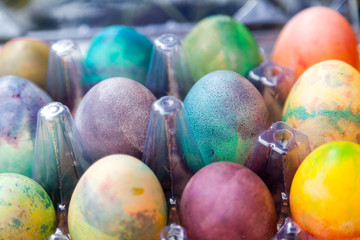 Group of Easter colored eggs in plastic container