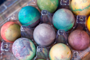 Group of Easter colored eggs in plastic container