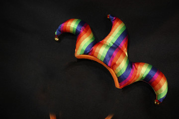 carnival jester hat on black background. - obrazy, fototapety, plakaty