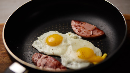 Fried eggs in a pan with sausage