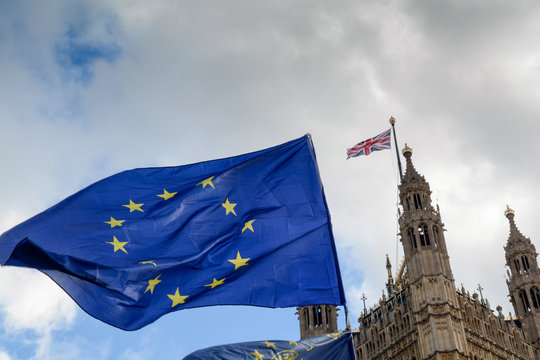 E.U. Flag flying in front of Union ack flag at Houses of Parliament London - Powered by Adobe