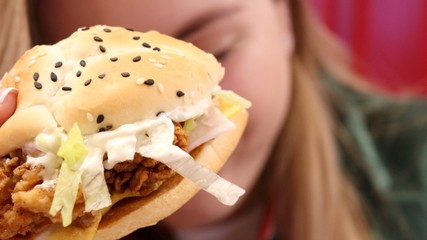 Close up tasty fried chicken burger and beautiful woman on the background