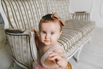 Fototapeta premium Happy little girl and beautiful next to a couch.