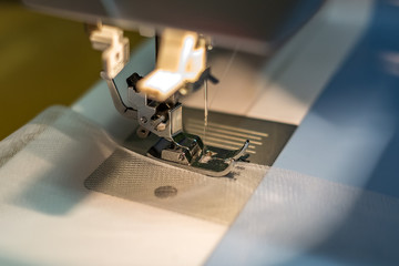 close up mechanism of sewing machine foot  with needle and thread