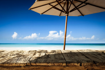 Desk of free space on beach and umbrella with shadow 
