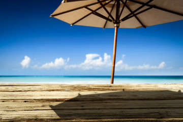 Desk of free space on beach and umbrella with shadow 