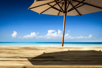 Desk of free space on beach and umbrella with shadow 