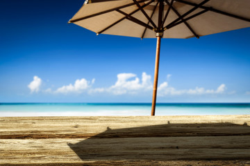 Desk of free space on beach and umbrella with shadow 