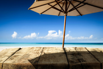 Desk of free space on beach and umbrella with shadow 